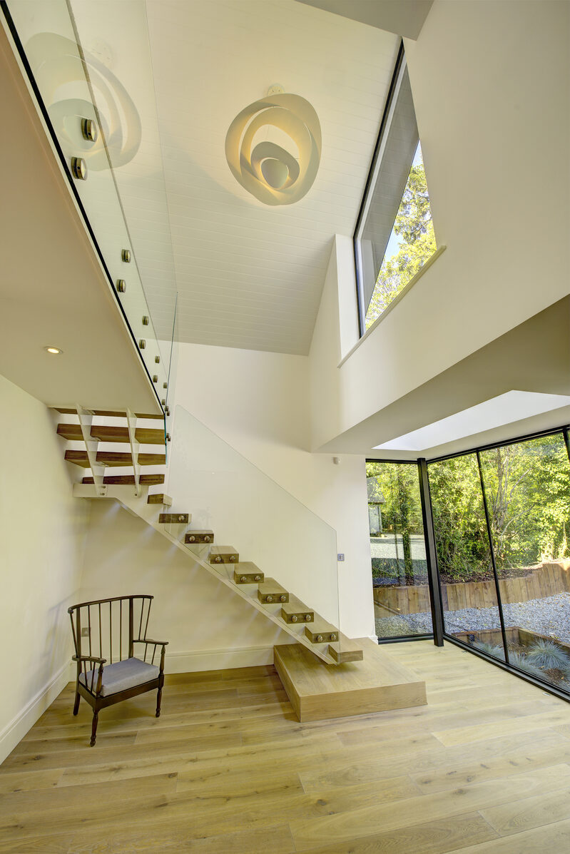 A bright light-filled hallway with double height feature and IQ Glass to new build