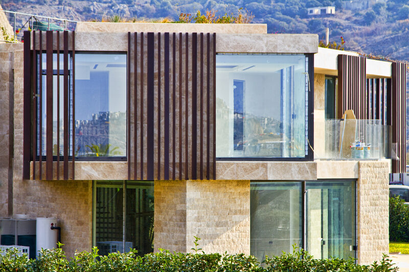 Timber cladding used in conjunction with large elevations of frameless glass