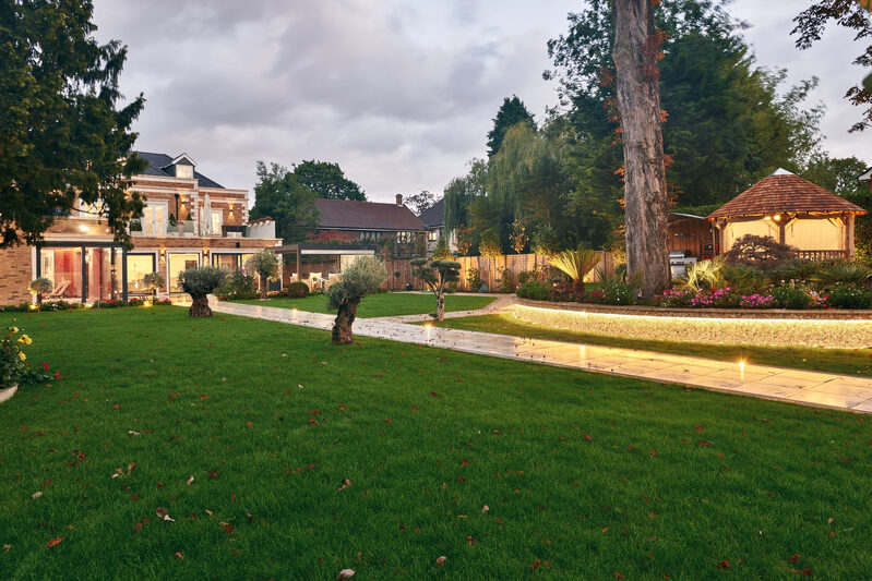 Outdoor space with layered lighting throughout garden design