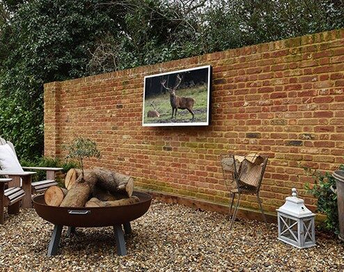 Wall mounted outdoor TV next to firepit