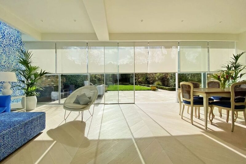 Concealed blinds partially lowered over floor-to-ceiling sliding glass doors