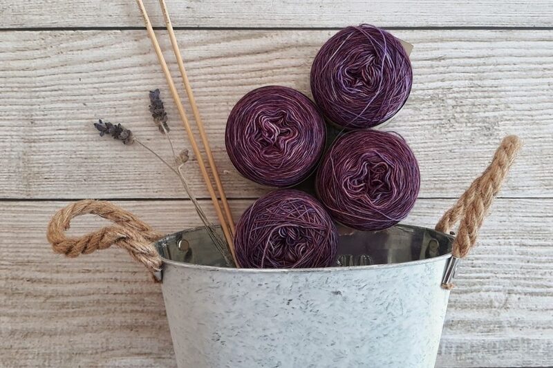 purple knitting wool and wooden needles