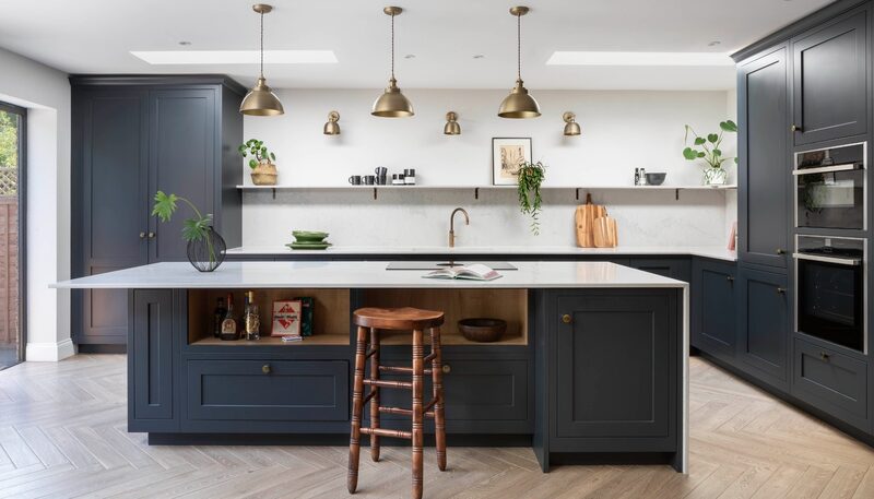 Porcelain vs quartz worktops: Franklands Close kitchen by Watermark Kitchens with dark Shaker cabinetry and a pale island worktop.