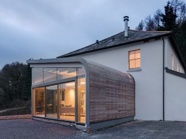 curved glass extension with wood exterior cladding