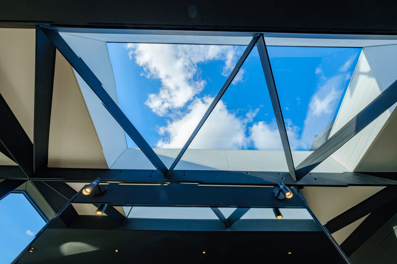 Frameless glass rooflights frame the lattice beam pattern to extended 15th Century barn