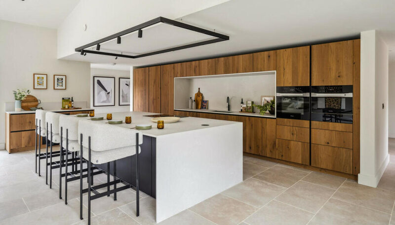 Porcelain vs quartz worktops: Hentucks Farm kitchen by Watermark Kitchens with timber cabinetry and a pale waterfall island.