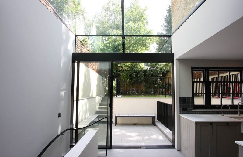Minimal framed sliding glass doors leading onto small garden in modern new build home