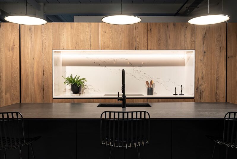Minimal and modern kitchen design, using warm wood tones and contrasting black surfaces