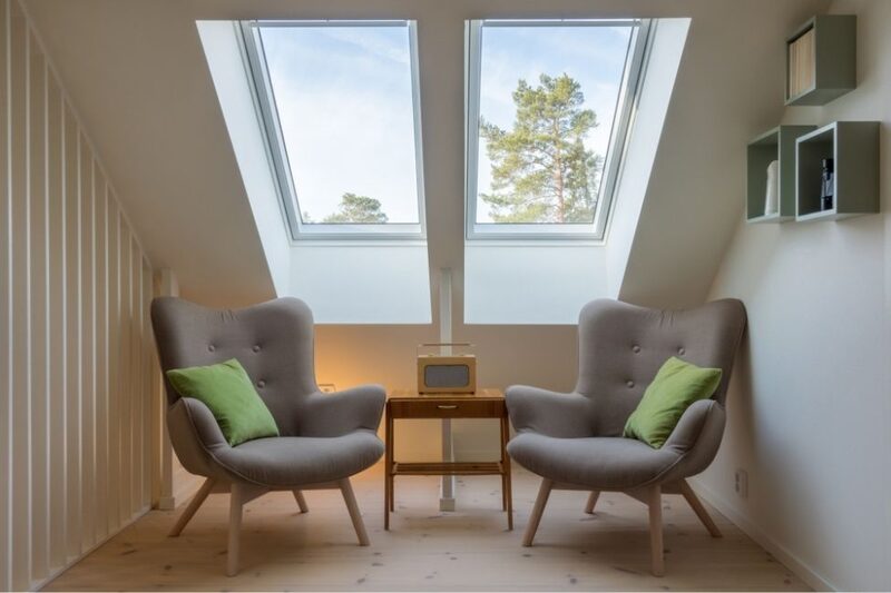 loft conversion with armchairs by sloped windows