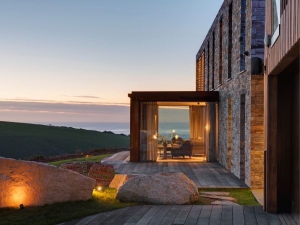 small glass box extension with frameless glass walls and slim framed sliding doors
