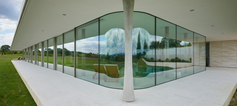 Curved frameless glass to house with pool slide