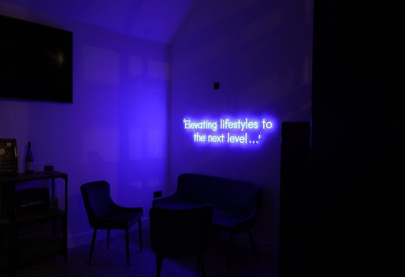 neon sign 'Elevating lifestyles to the next level...'