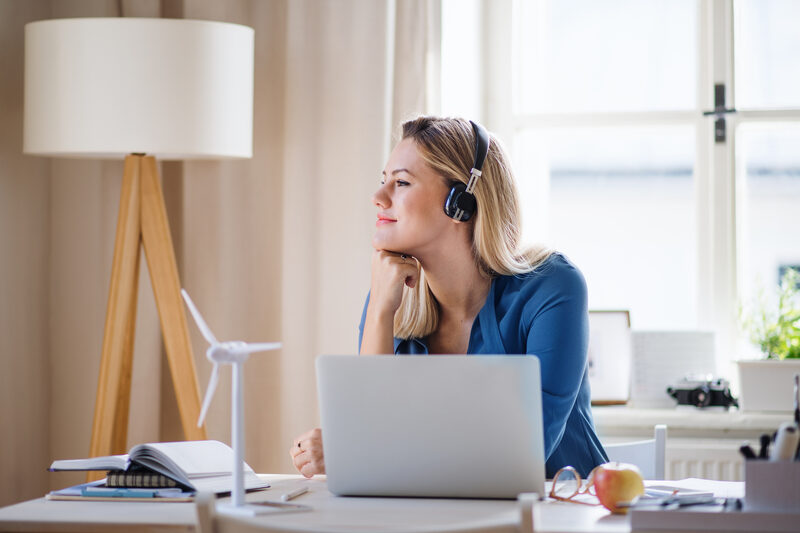 Woman working from home, with laptop, in brightly lit space